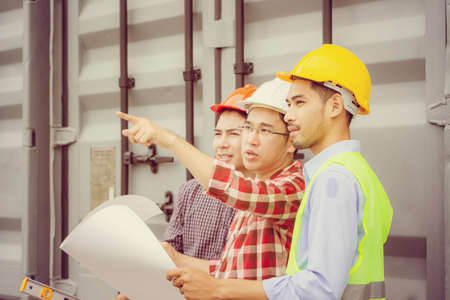 Engineer man and worker checking and planning project at construction site, Man looking into the sky over blurred backgroundの写真素材