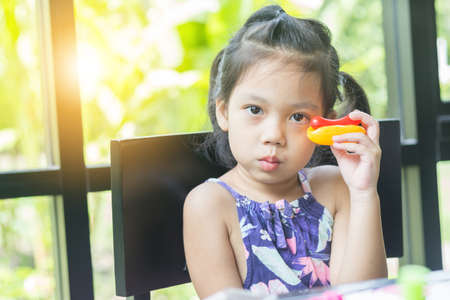 Portrait of little girl playing toy in coffee shop.の写真素材