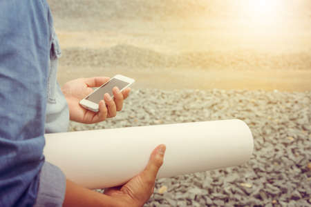 Close up of Engineering Businessman in blue jeans using mobile smartphone blurry background