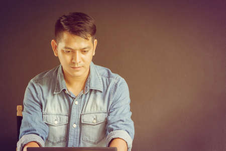 Business man in blue jean using a notebook for work in coffee shop.