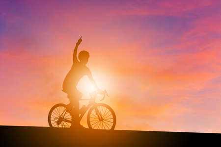 Silhouette of a cyclist male with clipping path riding a road bike at sunset, Sportsman in race concept.の写真素材