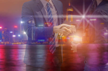 Double exposure of Businessman and business woman handshake on a city background, Success Teamwork and Partnership Conceptの写真素材