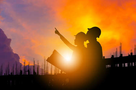 Silhouette of Engineer and worker building site background, construction site with clipping path at...