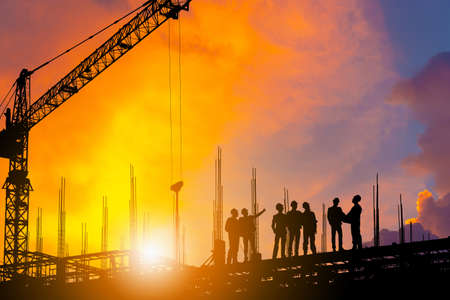 Silhouette of Engineer and worker on building site, construction site with clipping path at sunset...