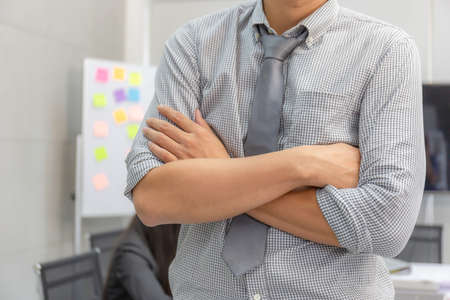 Young business man in smart casual wear crossed arms in the officeの写真素材