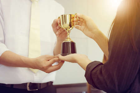 Business man and woman holding trophy success celebration team concept.の写真素材