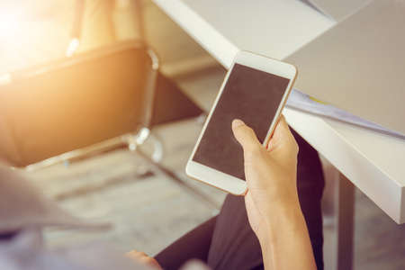 Close up of young business man using mobile smartphone at meeting room blurry background