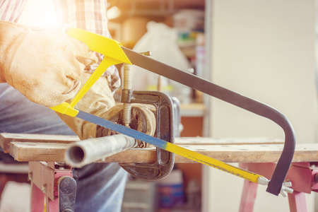 Close up of Craftsman worker sawing a steel pipe.の写真素材