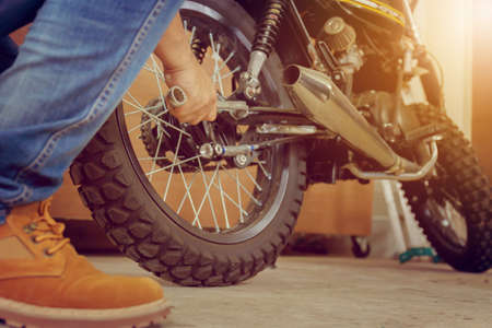 Close-up of Young man hand fixing motorcycle, Mechanical hobby and repairs concept.の写真素材