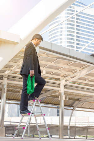Business Man Stand and Thinking on a stairs city Background, Thinks Big and Dreams Big Concept.の写真素材