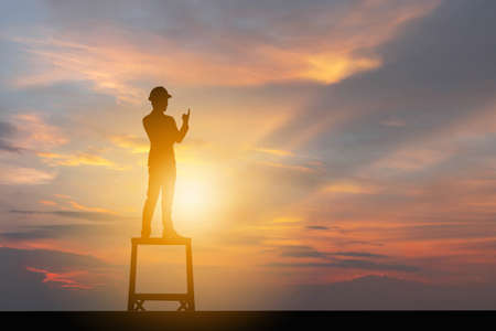 Silhouette of Business Engineer Man Celebration Success Happiness Evening Sky Sunset at Lake Background, I am number one and active life Concept.の写真素材
