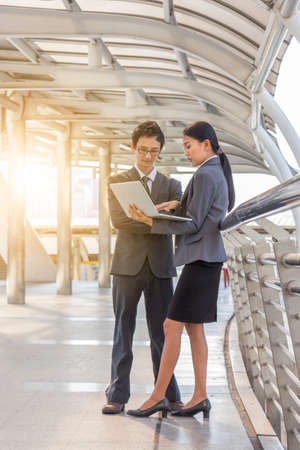 Businessman and businesswoman using digital laptop computer at Outside Office, Success and Happiness Team Concept.の写真素材