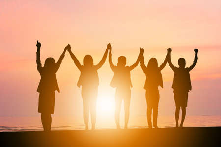 Silhouette of Business People Celebration Success Happiness Team at Sunset Evening Sky Backgroundの写真素材