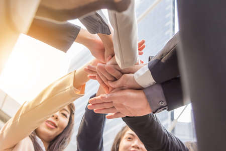 Success Teamwork Concept, Business people team joining hands outside office city backgroundの写真素材