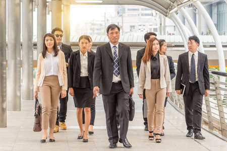 Group of happy young business team, businesspeople walking the outdoor office together, Success...