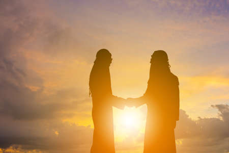 Silhouette of Arab middle eastern business man handshake at sunset background, Success and Happiness Team Concept.の写真素材