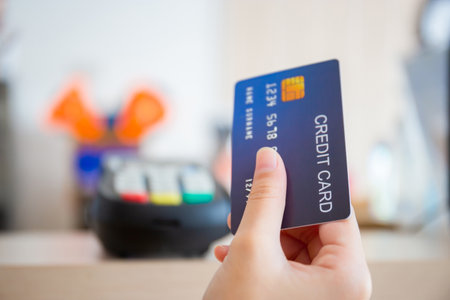 Hand of customer with credit card blurred credit card reader machine at bar counter, payment conceptの写真素材
