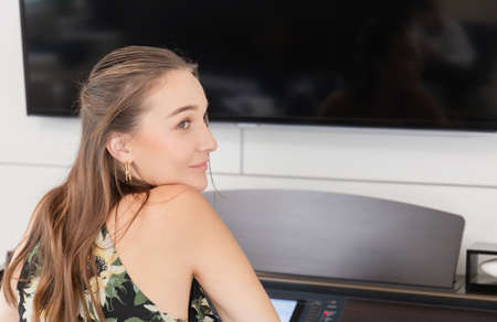 Beautiful woman in dress playing piano, Young girl playing grand piano at homeの写真素材