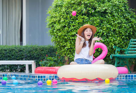 Young beautiful woman at the pool. Asian girl relaxing in swimming pool. Happiness lifestyle conceptsの写真素材