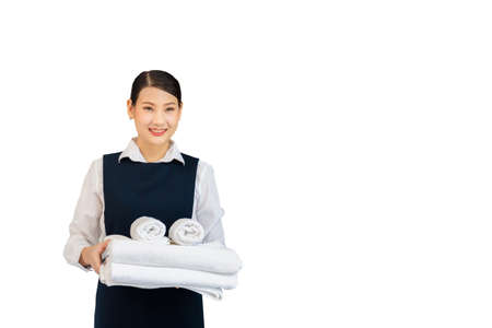 Room service holding fresh white bath towels on white background. Female housekeeper with towels.の写真素材