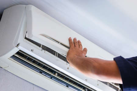 Air Conditioning Repair, Repairman fixing air conditioning system, Male technician service for repair and maintenance of air conditioners.の写真素材