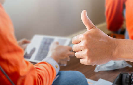 Technician man giving thumbs up with blurred internet worker team checking speedtest upload and download with tabletconceptsの写真素材