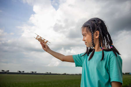 Asian child girl with airplane, child playing with toy airplane, Happy kid playing outdoorsの写真素材