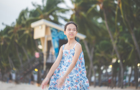 Portrait of little girl standing enjoy on the beach, Kid relaxing in summer evening sky outdoorの写真素材