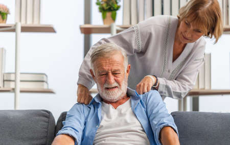Portrait of happy senior couple in living room, Elderly woman and a man relaxing on cozy sofa at home, Happy family conceptsの写真素材