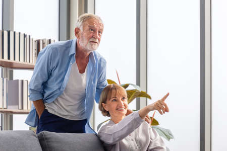 Portrait of happy senior couple in living room, Elderly woman and a man relaxing on cozy sofa at home, Happy family conceptsの写真素材