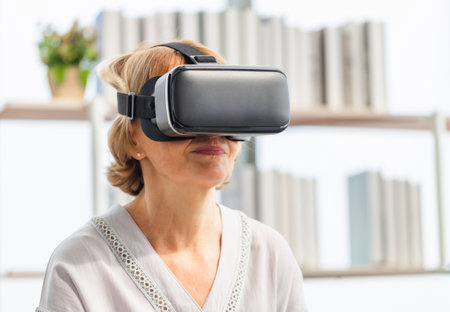 Senior woman sitting on the sofa having fun with virtual reality glasses, Happy elderly technology conceptsの写真素材