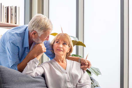Portrait of happy senior couple in living room, Elderly woman and a man relaxing on cozy sofa at home, Happy family conceptsの写真素材