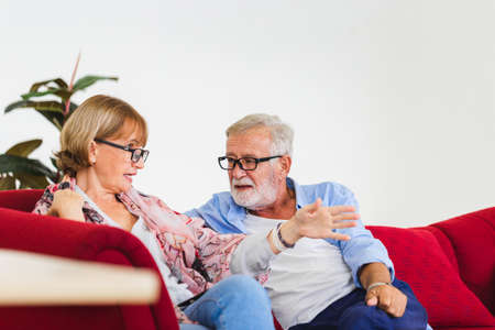 Portrait of happy senior couple in living room, Elderly woman and a man relaxing on cozy sofa at home, Happy family conceptsの写真素材