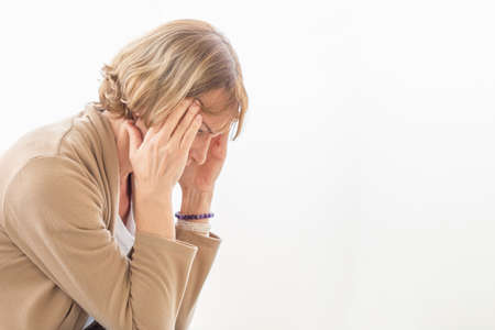 Woman having headache and touching her head while suffering from a migraineの写真素材