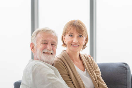 Portrait of happy senior couple in living room, Elderly woman and a man on cozy sofa at home, Happy family conceptsの写真素材
