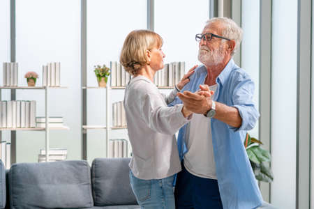 Portrait of happy senior couple dancing in living room, Elderly woman and a man dancing, Happy family conceptsの写真素材