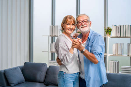Portrait of happy senior couple dancing in living room, Elderly woman and a man dancing, Happy family conceptsの写真素材