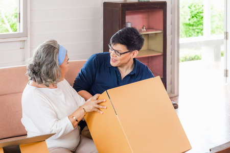 Senior asian mother and middle aged son sitting relax in living room on moving day, Happiness Asian family conceptsの写真素材