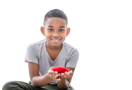 Smiling boy holding red heart shape with clipping path on white background