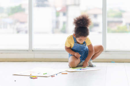 Cheerful kid draw a picture in creativity in living room, Child girl drawing on floor indoors