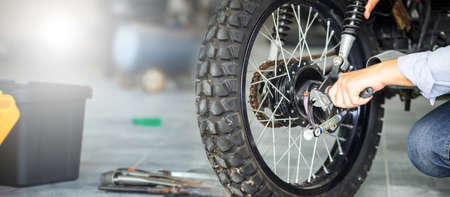 Repairing and maintenance concepts, Man repairing motorcycle in repair shop, Mechanic fixing...