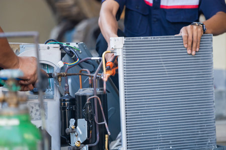 Air Conditioning Repair team use fuel gases and oxygen to weld or cut metals, Oxy-fuel welding and oxy-fuel cutting processes, repairman on the floor fixing air conditioning systemの写真素材