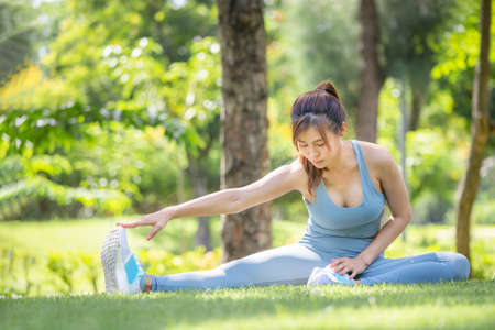 Fitness woman stretching muscles before sport activity, Young sport woman stretching and preparing to run in parkの写真素材