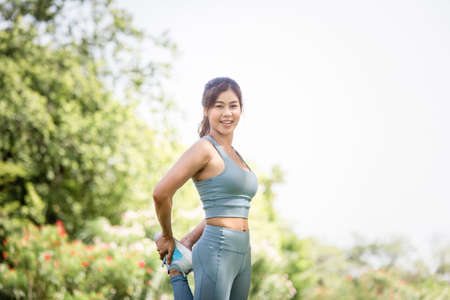 Sportswoman warming up outdoors, Fitness woman in sport clothes warm up training do stretch exercise outdoorの写真素材