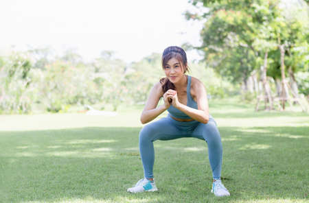 Sportswoman warming up outdoors, Fitness woman in sport clothes warm up training do stretch exercise outdoorの写真素材