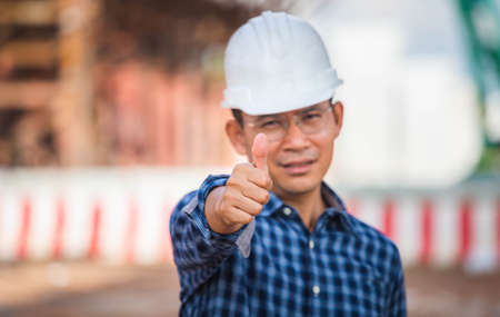 Engineer checking project at the building site, Selective focus of Man in hardhat showing thumbs up at infrastructure construction siteの写真素材