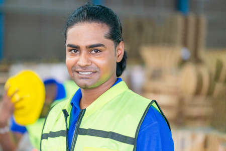 Portrait of Worker wearing safety vest standing in the warehouse, Man looking at camera with blurred background and copy spaceの写真素材