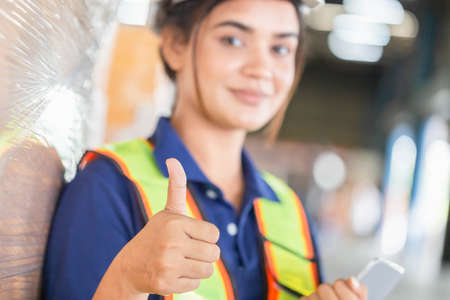 Cheerful female worker showing thumbs up, Manual workers working in the warehouse, Female warehouse...
