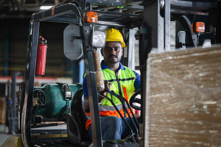 Worker on forklift, Manual workers working in warehouse, Worker driver at warehouse forklift loader worksの写真素材