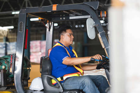 Worker on forklift, Manual workers working in warehouse, Worker driver at warehouse forklift loader worksの写真素材